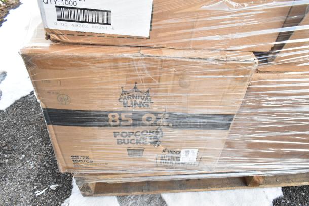 Sealed pallet of Carnival King 85 oz popcorn buckets, labeled and wrapped in plastic, on a snowy outdoor surface.