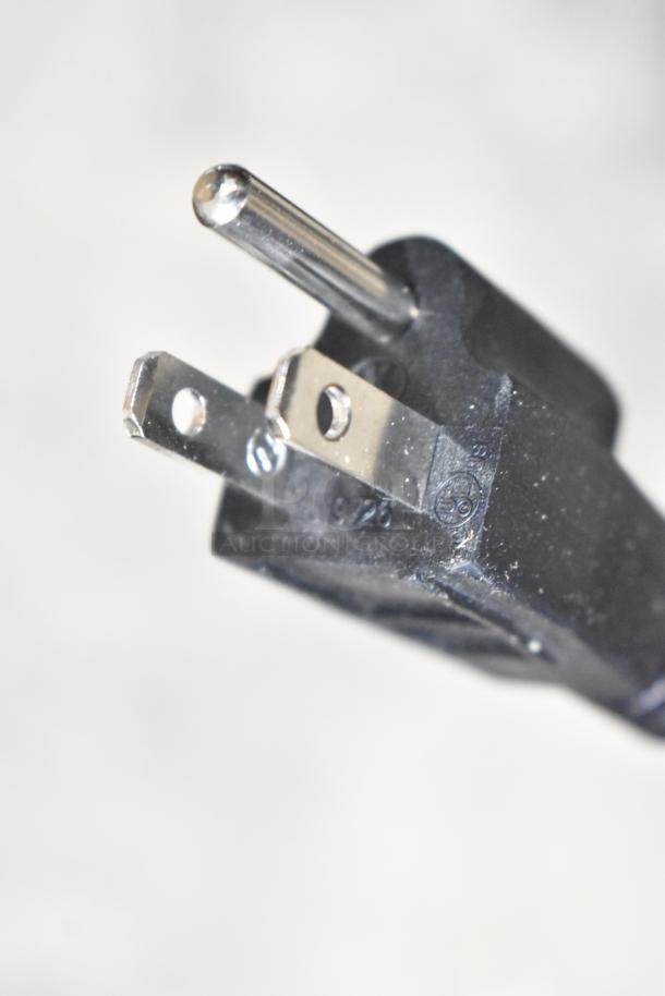 Close-up of a 120V power plug for the 2025 VitaMix VM0800 stainless steel commercial drink mixer, showing prongs and markings.