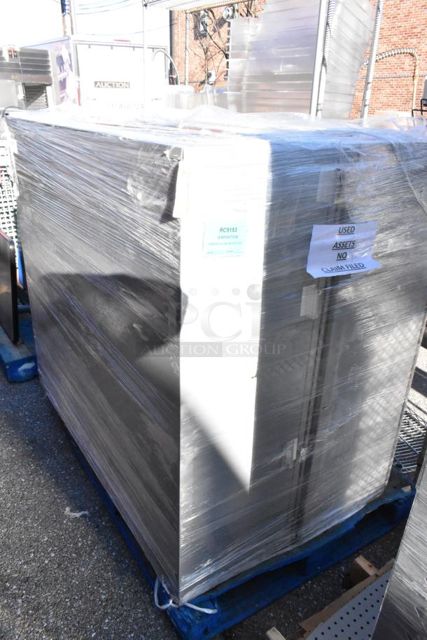 Two gray metal units, wrapped, on pallets. Tags indicate "Used Assets" and "RC9153 Disposition". Auction item.