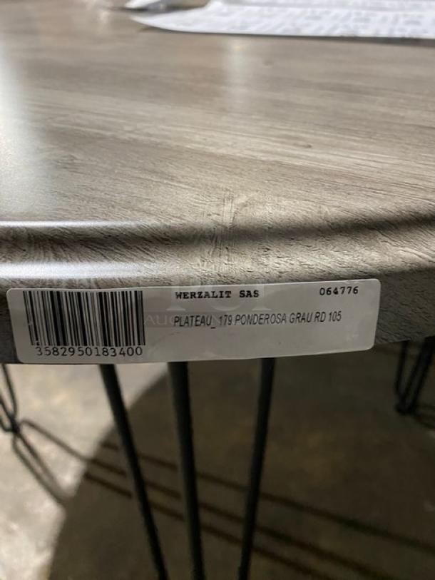 Brand new Werzalit Ponderosa Grey 41.33" round tabletop with matte steel hairpin legs. Model 064776, tag barcode visible.