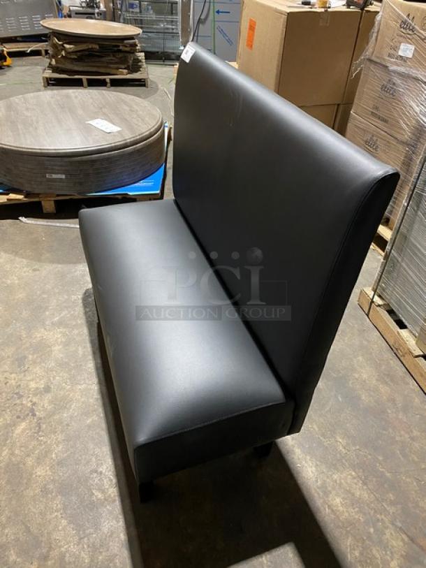Brand new black upholstered restaurant booth, commercial-grade, on legs, pristine condition, ideal for dining settings.
