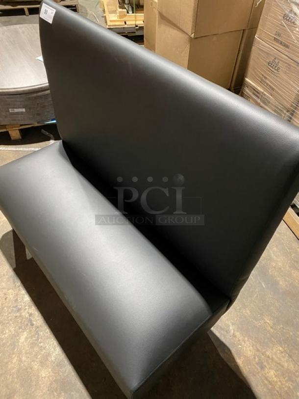 Brand new commercial black upholstered restaurant booth with legs, pristine condition, ideal for dining settings.
