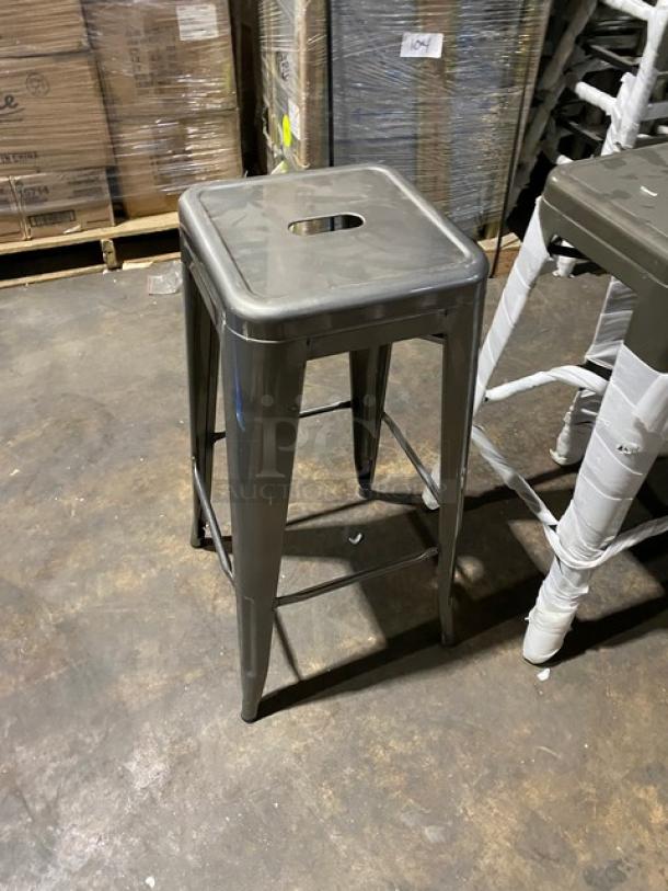 Brand new gunmetal grey backless industrial-style stackable bar stool in pristine condition; durable metal design.
