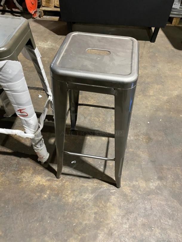 Brand new gunmetal grey industrial-style stackable bar stool, backless, commercial-grade, durable steel, modern design.