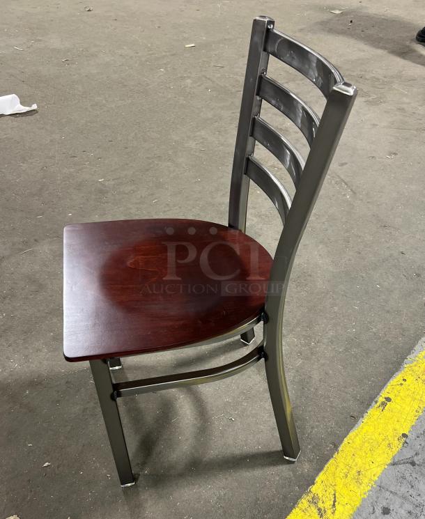 Brand new metal ladder-back dining chair with stackable frame and mahogany wooden seat in excellent condition.