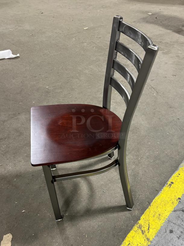 "Brand new metal ladder-back dining chair with mahogany wooden seat, stackable frame, commercial quality."