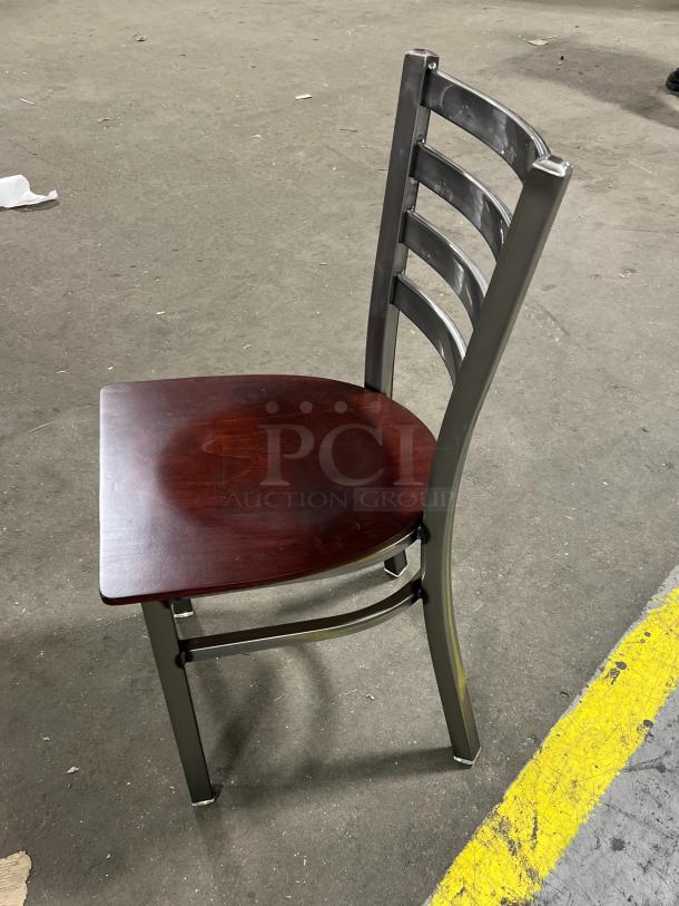 Brand new commercial stackable dining chair with metal ladder-back frame and mahogany wooden seat.