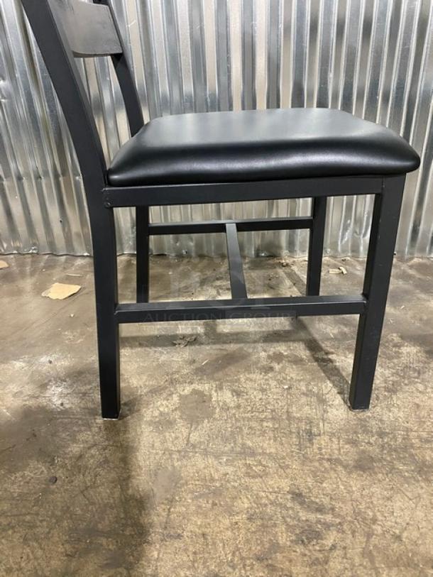Brand new heavy-duty black metal slotted ladder back dining chair with cognac seat. Durable, stylish design.
