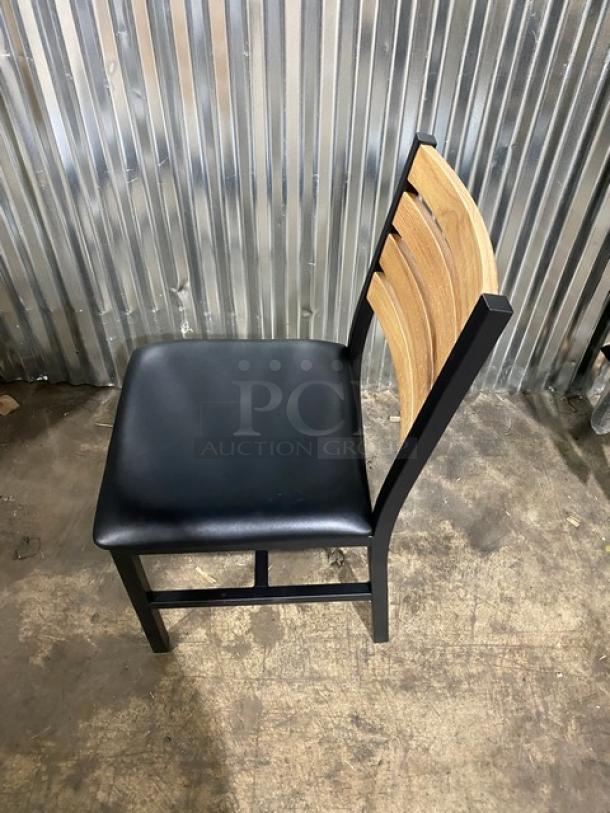 Brand new welded black metal dining chair with wooden slotted ladder back and black seat. Heavy-duty construction.