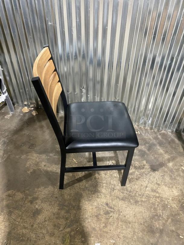 Brand new heavy-duty black metal dining chair with slotted wooden ladder back and black seat.