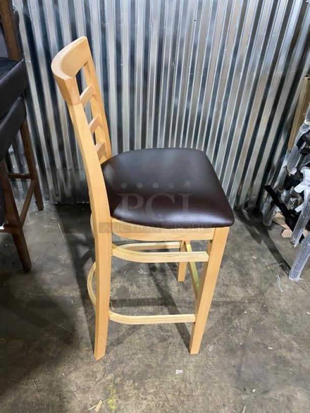 Bar-height stool, model 4650, featuring a wooden frame and chocolate cushioned seat. New condition.