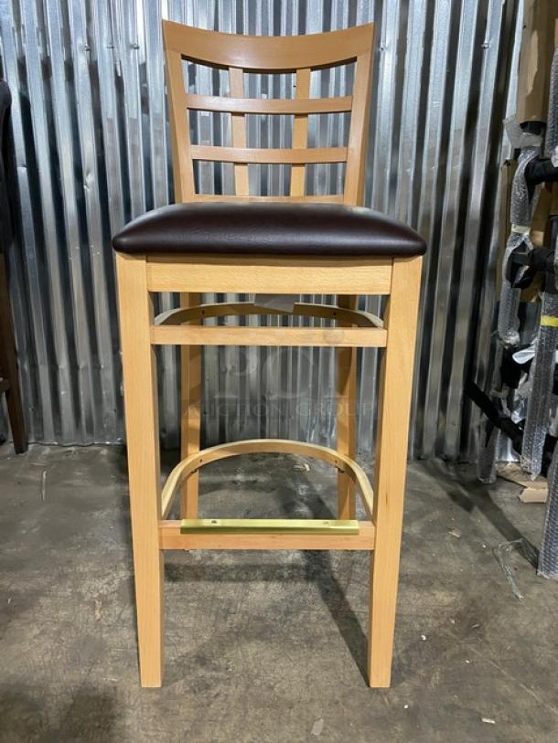 Bar-height wooden stool with chocolate cushioned seat, model 4650, new condition. Checker pattern backrest.