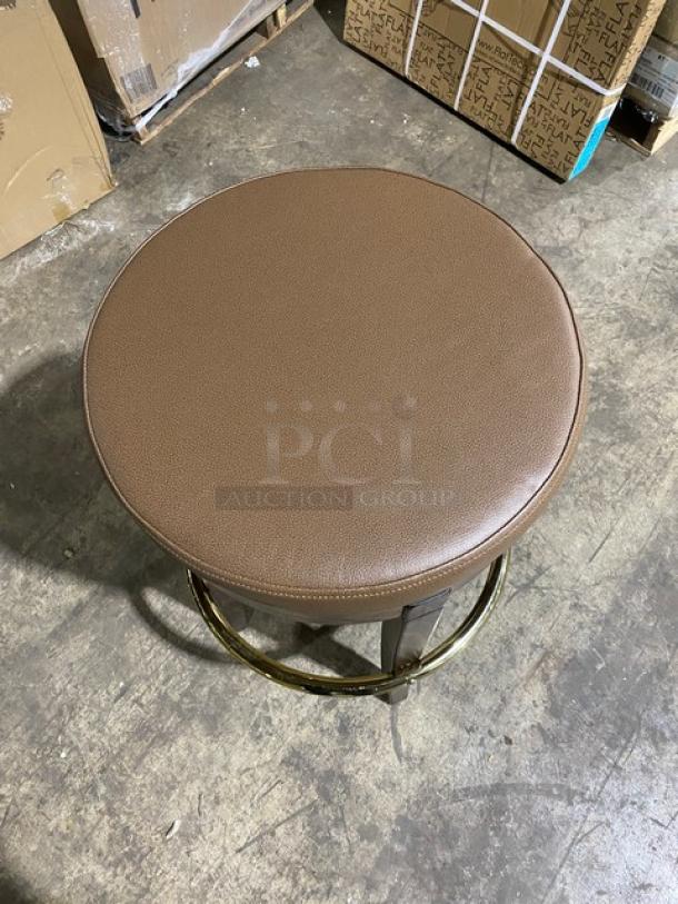 Brand new Mid-Century Modern style swivel bar stool with brass finish and tan upholstered seat, shown in excellent condition.