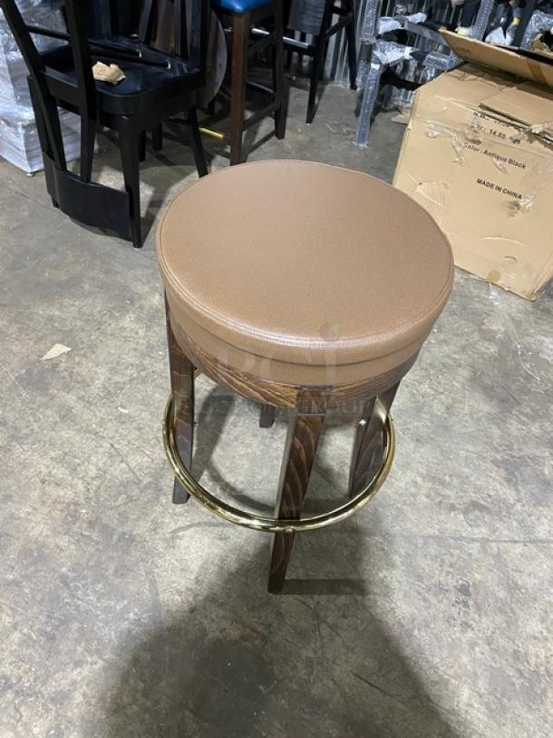 Mid-Century Modern style swivel bar stool with brass finish, tan upholstered seat, and wood legs. Brand new condition.