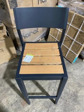 Brand new aluminum outdoor bar-height stool with teak slats, in excellent condition, featuring a visible tag with product details.