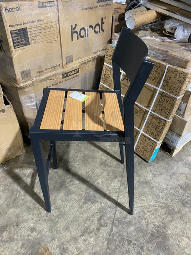Brand new aluminum black outdoor bar-height stool with light brown imitation teak slat seat, tag visible on seat.