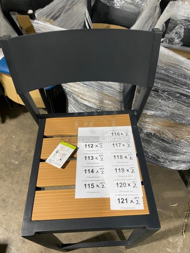 Black aluminum outdoor bar-height stool with light brown imitation teak slat seat, new condition. Auction tags visible.