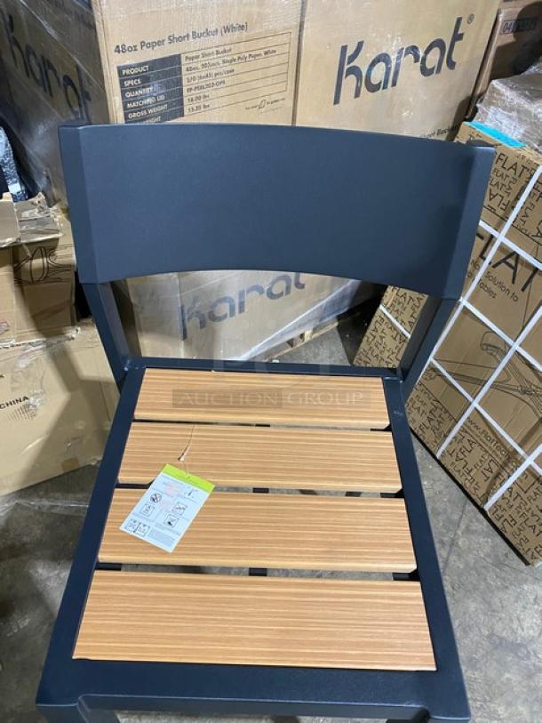 Brand new black aluminum outdoor bar-height stool with light brown imitation teak slat seat and a tag detailing assembly instructions.