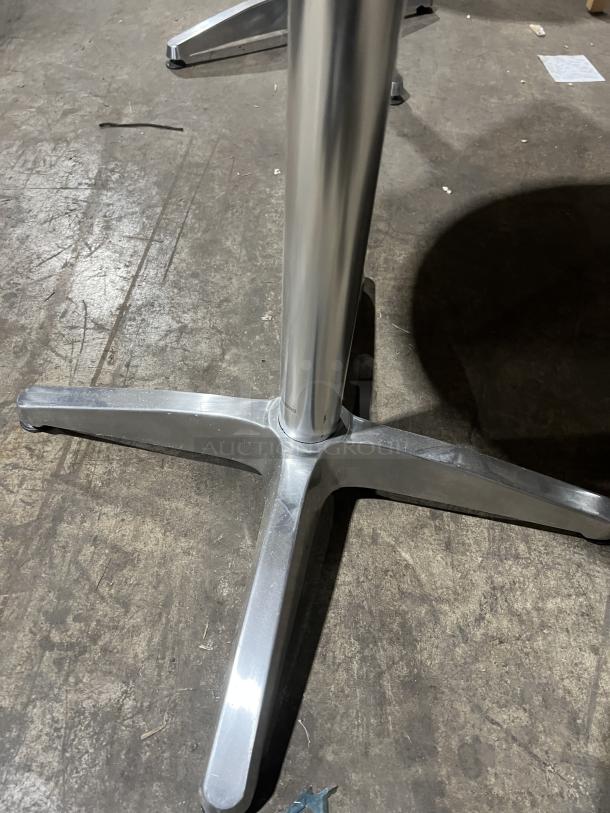 Commercial round bistro table base, silver metal, sturdy four-legged support, suitable for indoor/outdoor use.