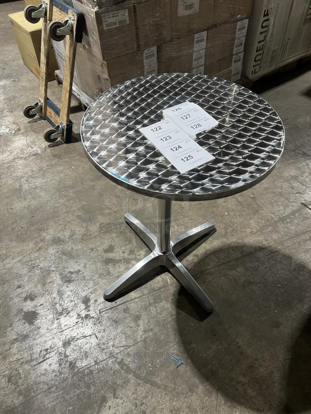 Commercial round bistro table, metal grate top, four-legged base, suitable for indoor/outdoor use. Tags numbered 122-128.