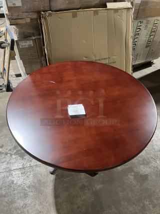 Round mahogany dining table with metal pedestal base; commercial quality, in excellent condition, no visible markings.