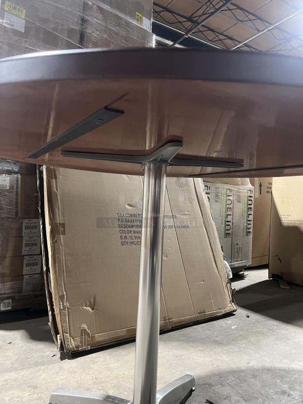 Commercial mahogany round dining table with metal pedestal base, featuring a polished finish, in new condition.