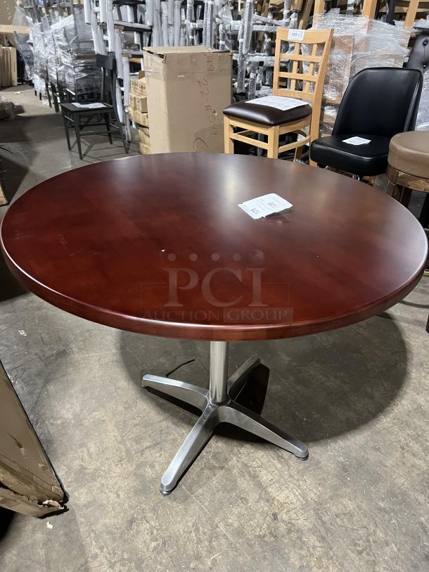 Round mahogany dining table with metal pedestal base, commercial grade, excellent condition.