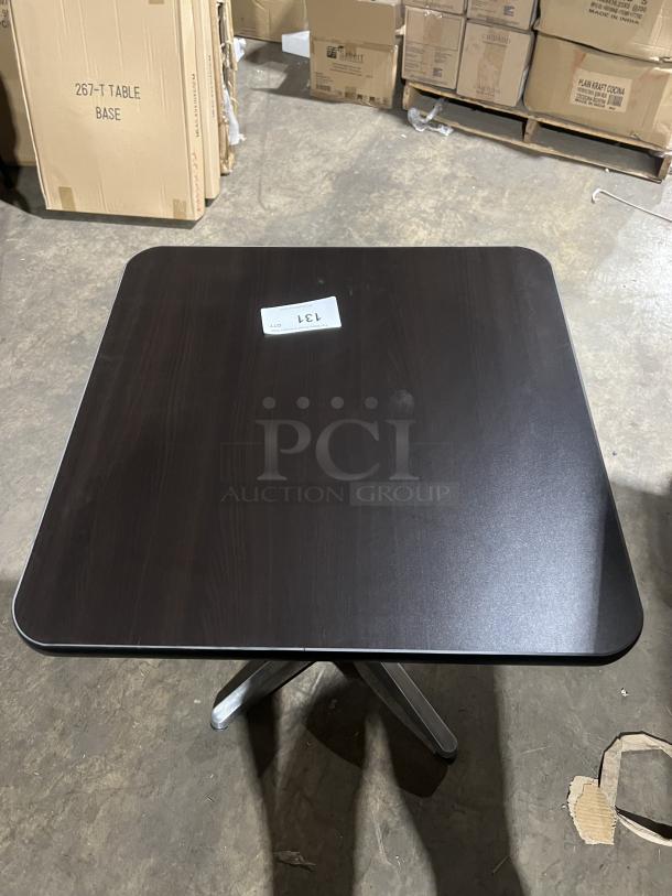 Commercial black square dining table with modern style; stainless steel pedestal base; suitable for indoor/outdoor use.