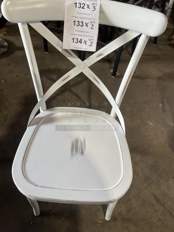 Commercial white cross-back stackable dining chair, slightly worn seat, label showing lot quantities and auction website.
