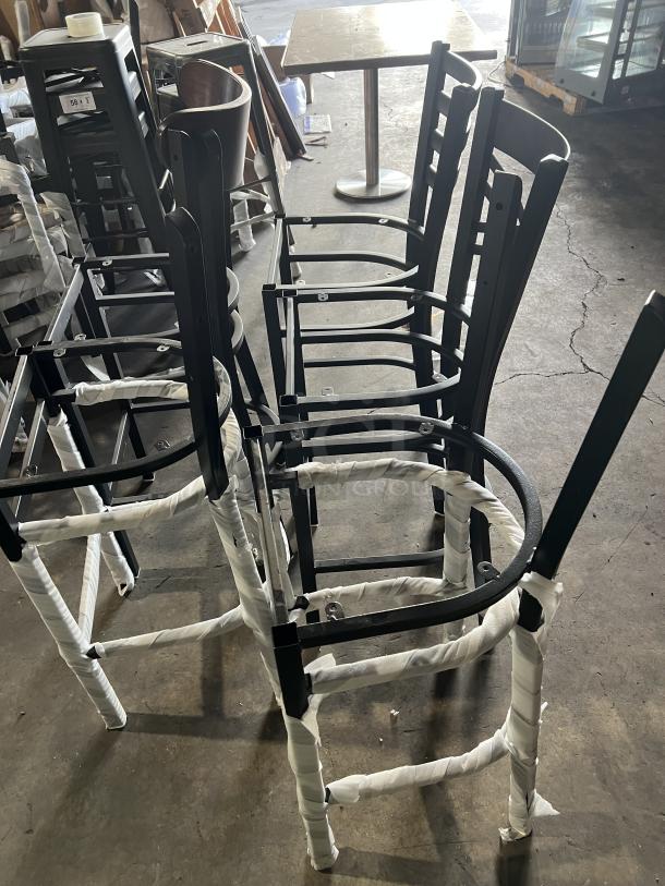 Brand new miscellaneous dining chairs, metal frames, wrapped for protection, shown in warehouse setting.