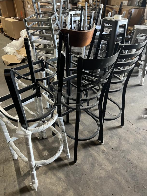 A collection of brand new miscellaneous dining chairs in various styles, wrapped in protective packaging, showcased in a warehouse.