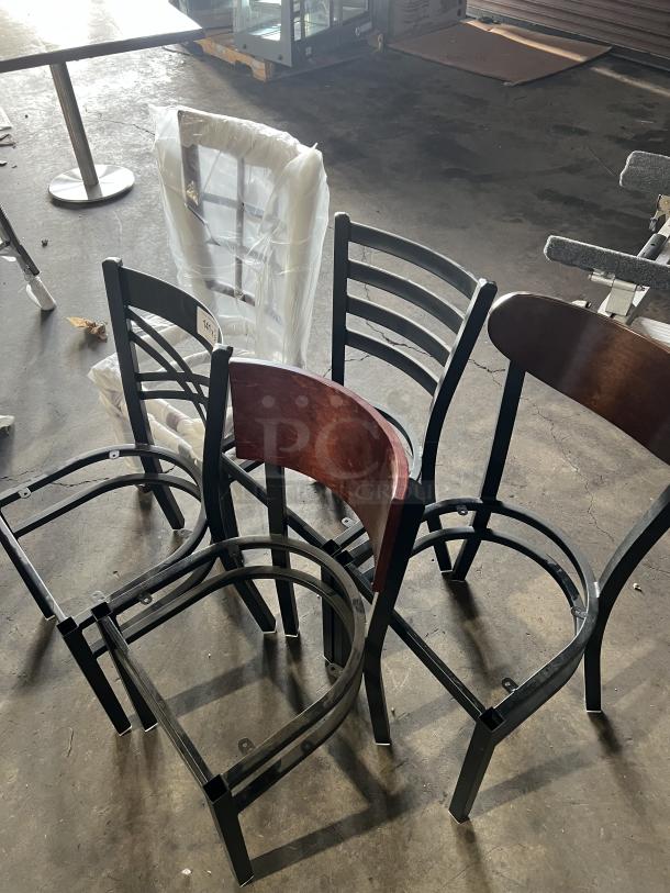 A set of brand new, miscellaneous dining chairs, unassembled, with black metal frames and wood accents. Some wrapped in plastic.