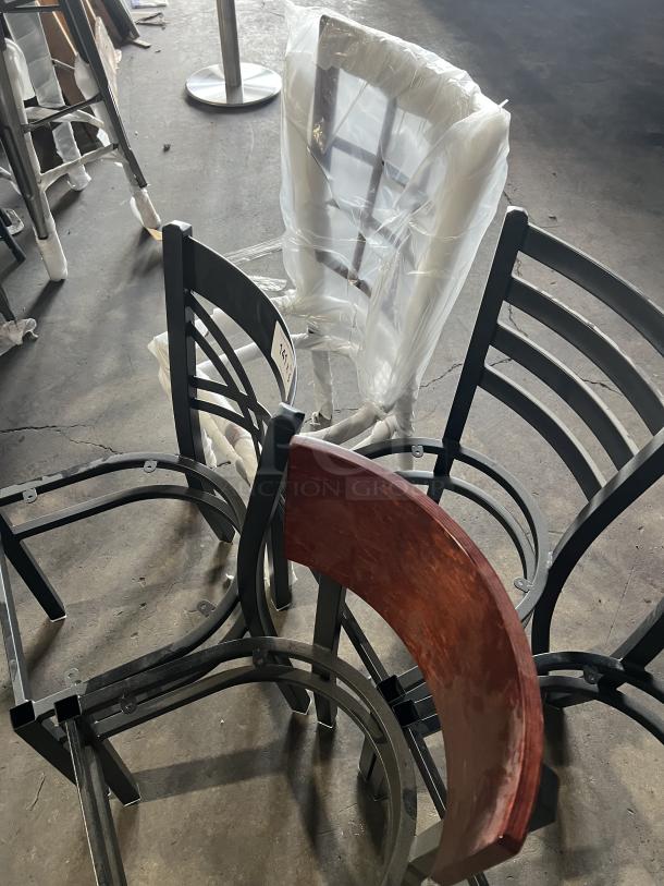 A lot of brand new miscellaneous dining chairs, featuring various designs and materials, some wrapped in protective plastic.