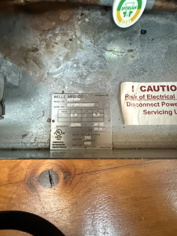 Wells RCF-200 refrigerated drop-in cold pan label, showing model info and electrical details. Warning sign visible nearby.