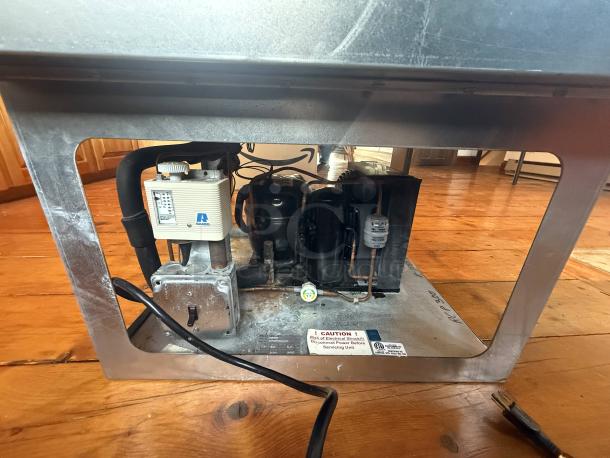 Wells RCF-200 refrigerated drop-in cold pan, showing underside components, wiring, and caution label. Ideal for catering use.