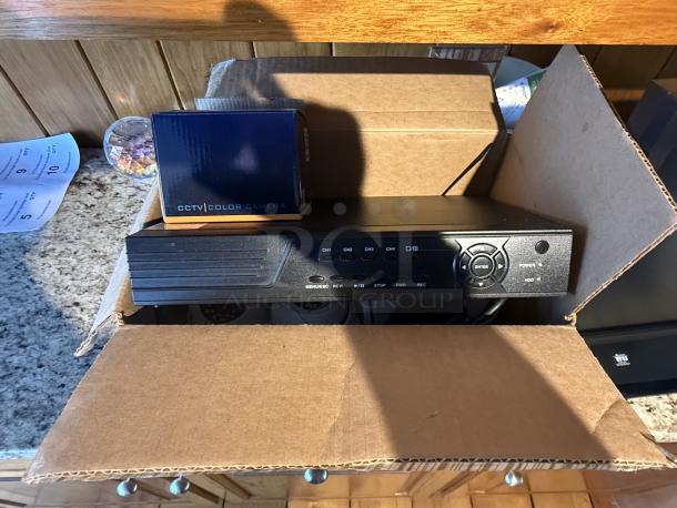 SYRF04-KIT2 CCTV security system in open box, showing DVR and camera packaging. Ideal for small business monitoring.