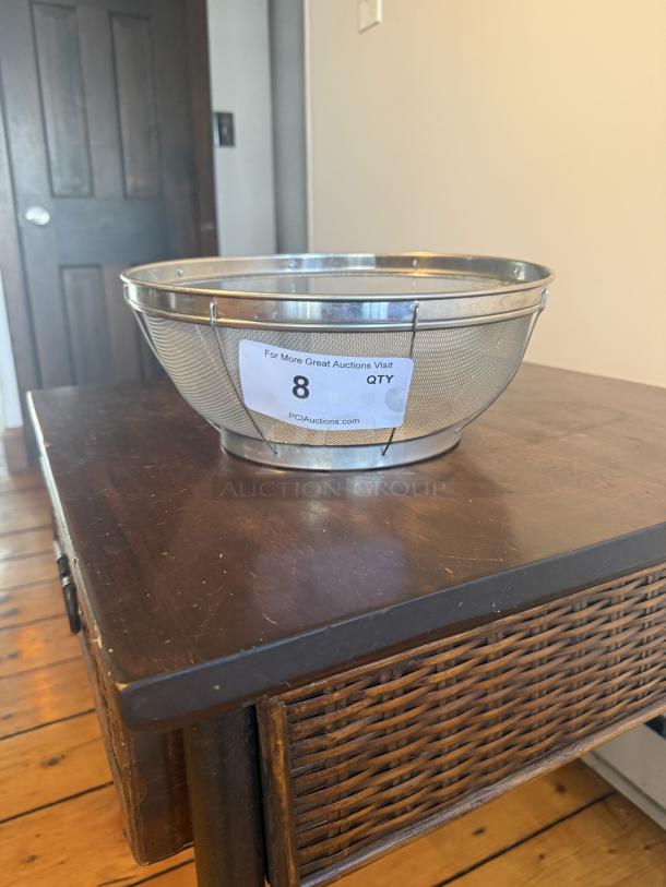 Commercial 12" metal strainer with wire mesh, ideal for high-volume prep. Tag reads "8 QTY" and "PCIAuctions.com".