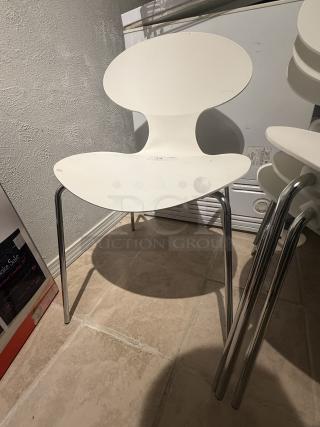 Set of 8 Arne Jacobsen Series 7 chairs. White molded seats with hourglass design, chrome-plated legs. Good condition, stackable.