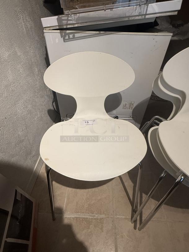 Set of 8 Arne Jacobsen Series 7 chairs with white hourglass seats, chrome legs. Stackable, minimalist design, light wear shown.