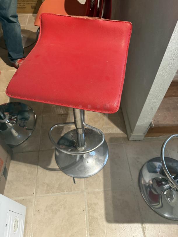 Bright red bar stool with chrome base, 29" height, 360-degree swivel. Minor seat tear, otherwise in good condition.