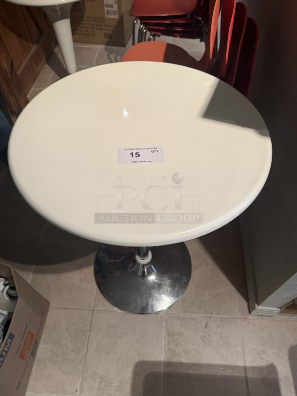 Set of 5 adjustable hydraulic bistro tables, white round tops, chrome pedestal base, excellent condition. Auction tag reads "15 QTY".