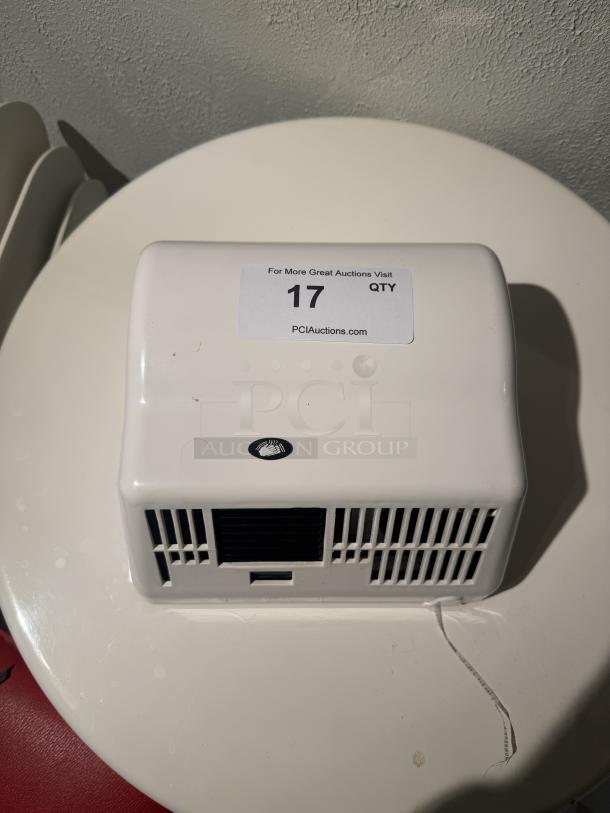 American Dryer GX1 hand dryer, white, rectangular design with vents and hand icon. Tag: "17 QTY PCIAuctions.com".