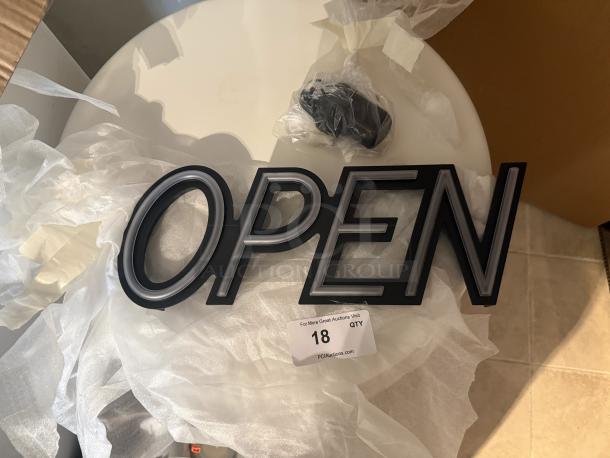 Modern LED "OPEN" sign in sleek black, new condition, includes power adapter. Auction item tag: 18.