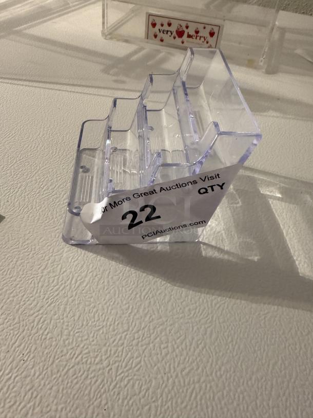 Clear 3-tier acrylic business card holder. Durable, versatile design for desks or trade shows. Holds multiple card stacks. Auction label visible.