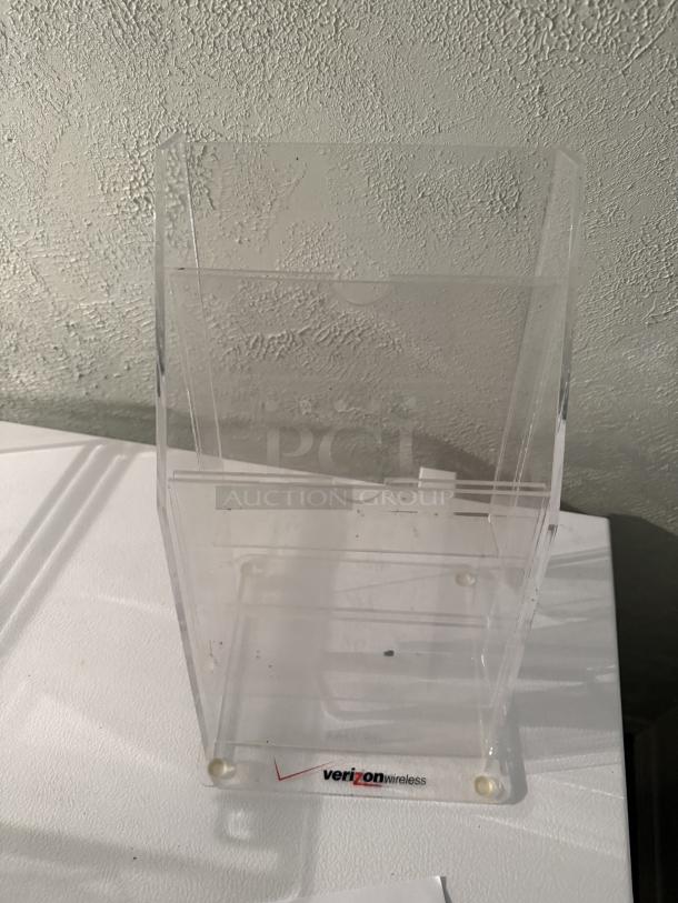Clear 4-tier acrylic pamphlet holder for 4"x9" brochures, fits 75 per pocket. Verizon Wireless branding on base.