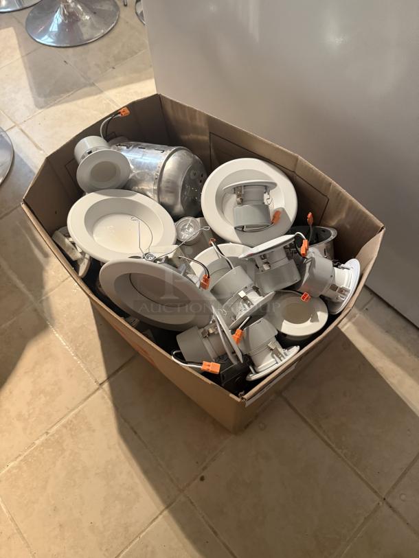 Box of 13 used LED recessed light fixtures with trims, featuring orange quick-connect wiring. Modern, energy-efficient design.