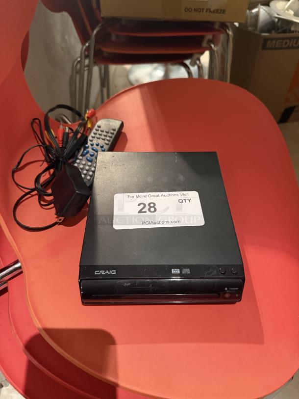 Craig compact DVD/CD player with remote and RCA cables, in used condition. Label indicates auction item number 28.