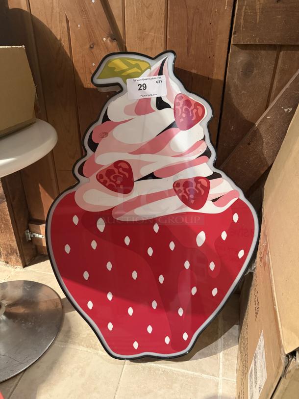 Large LED sign shaped like a strawberry sundae with pink and white whipped cream, strawberry slices, and label marked "29".