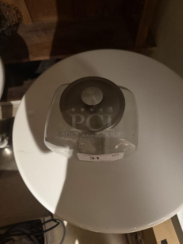 Glass candy jar with metal lid, rounded square shape, handle on top. "QTY 31" label visible. Good used condition.