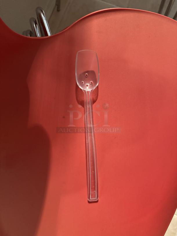 Clear slotted plastic serving spoon. Ideal for catering, with a unique draining design. Bulk lot of 40, perfect for events.